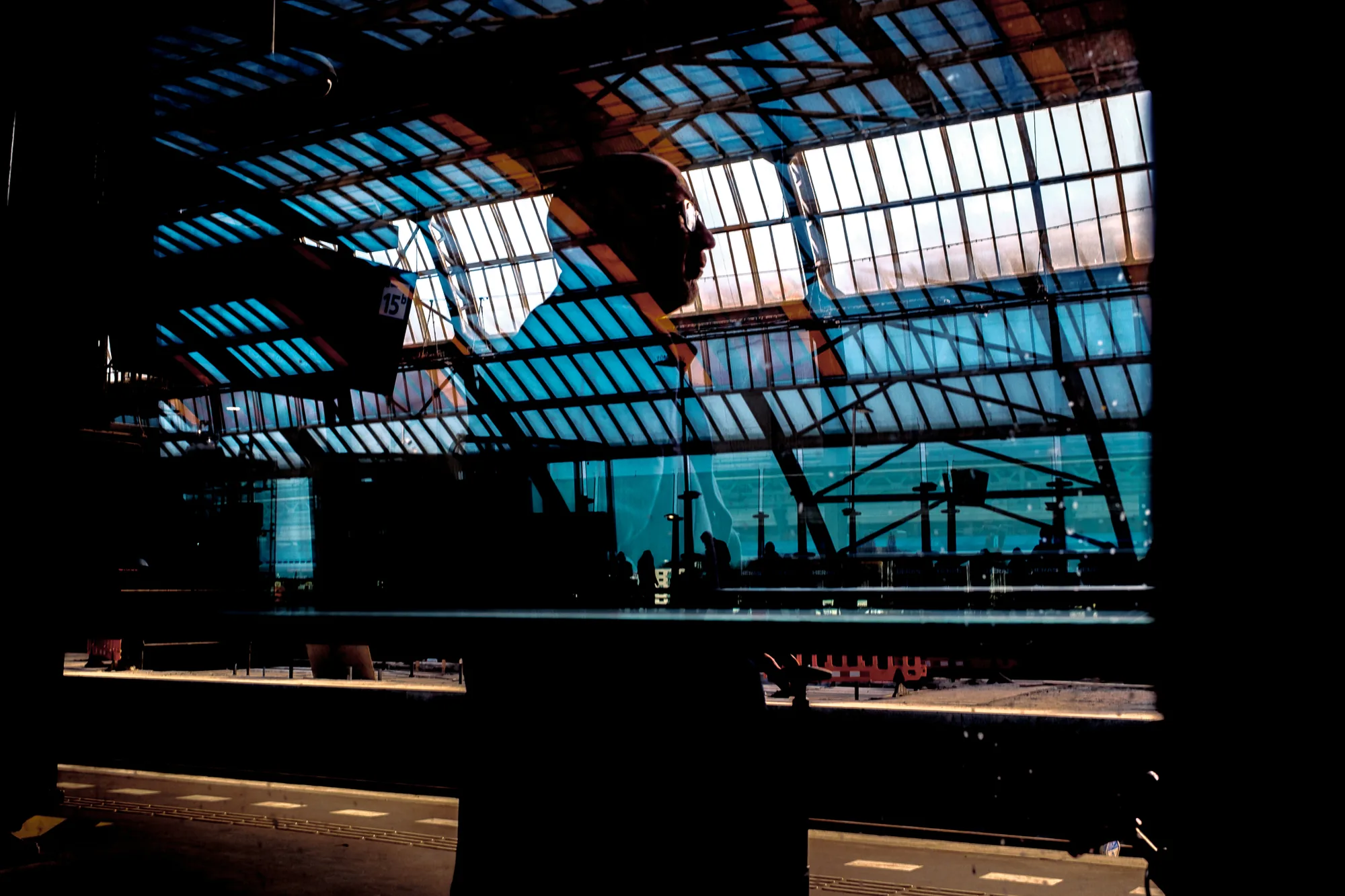 Silhouettes beneath a station's glass arches
